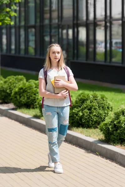 Adolescente estudiante chica con libros caminando en la calle - foto de stock