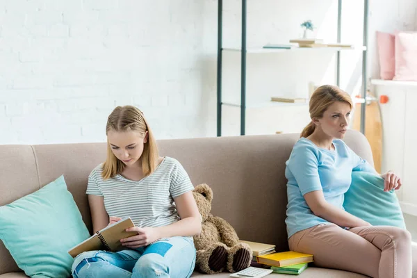 Mother and daughter sitting on couch after quarrel — Stock Photo