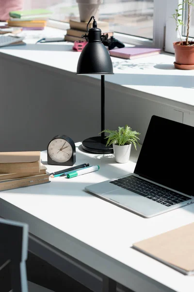 Plan rapproché du lieu de travail moderne avec ordinateur portable et livres à la maison — Stock Photo