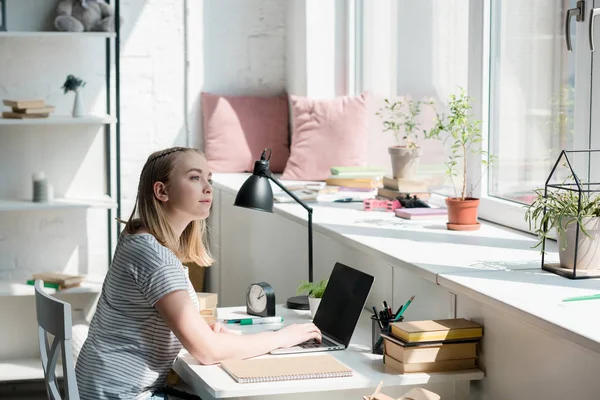 Thoughtful teen student girl sitting at work desk at home — Stock Photo