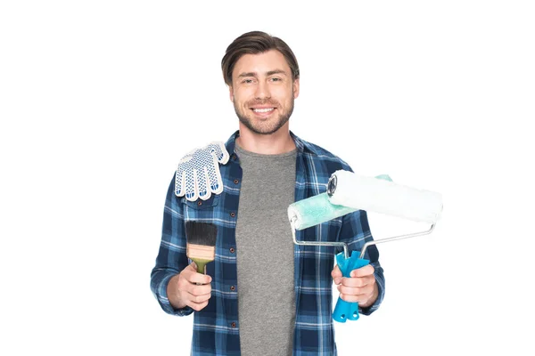Homme souriant avec rouleaux de peinture, gants de protection et pinceau isolé sur fond blanc — Photo de stock