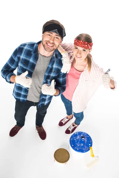 Alto ângulo de visão de casal sorridente em luvas de proteção fazendo polegares acima gesto isolado no fundo branco — Fotografia de Stock