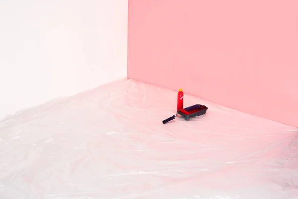 Крупним планом вид пляшки, лоток для ролика і фарбувальний ролик перед пофарбованою стіною — стокове фото