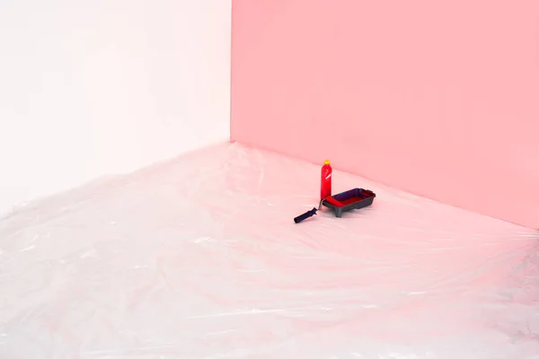 Close up view of bottle, roller tray and paint roller in front of painted wall — Stock Photo