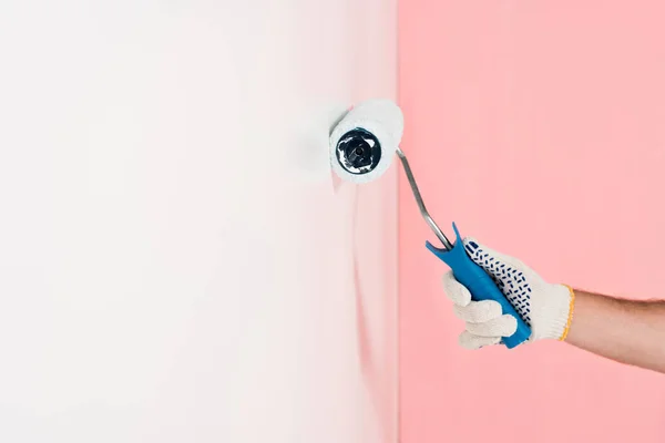 Частковий вид людини в захисній рукавичці живопис стіна в білому кольорі за допомогою фарби ролика — стокове фото