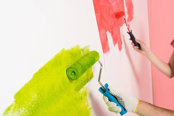 Recortado tiro de pareja pintura pared por rodillos de pintura - foto de stock