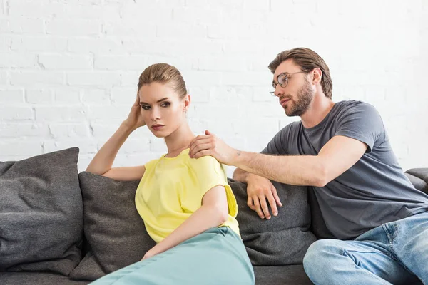 Young man trying to cheering up upset girlfriend after quarrel — Stock Photo