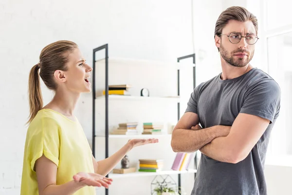 Side view of woman yelling at boyfriend while she standing with crossed hands — Stock Photo