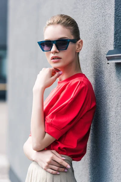 Élégant jeune modèle féminin en lunettes de soleil avec la main sur le menton — Photo de stock