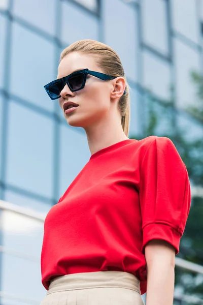 Низький кут зору стильної молодої жіночої моделі в сонцезахисних окулярах — Stock Photo