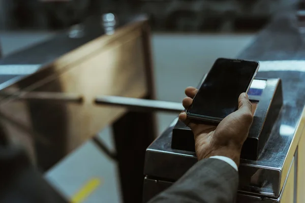 Vue rapprochée de l'homme d'affaires payant le tarif des transports publics via smartphone — Photo de stock