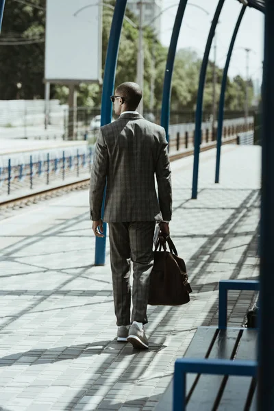 Бізнесмен у стильному костюмі, що йде на зупинці громадського транспорту — стокове фото