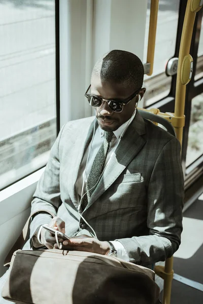 Молодих афро-американських бізнесмен, слухаючи музику під час прийому поїзд — стокове фото
