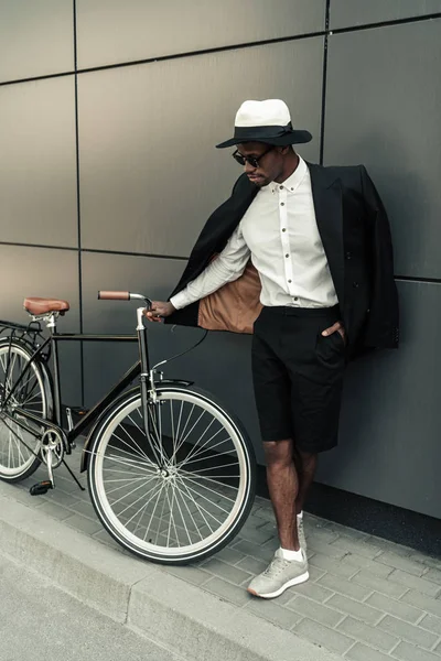 Uomo elegante che indossa camicia bianca e giacca in piedi vicino alla sua bicicletta — Foto stock