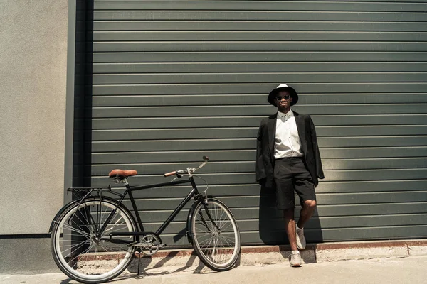Stilvoller Mann in weißem Hemd und Jacke posiert mit seinem Fahrrad — Stockfoto