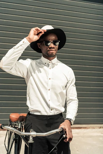 Homem elegante vestindo camisa branca e segurando sua bicicleta — Fotografia de Stock