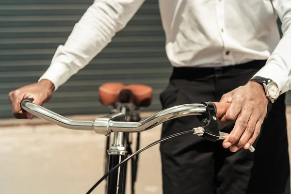 Vue recadrée d'un homme afro-américain tenant son vélo — Photo de stock