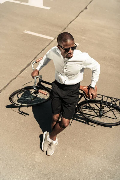 Homme élégant portant une chemise blanche appuyée sur son vélo — Photo de stock