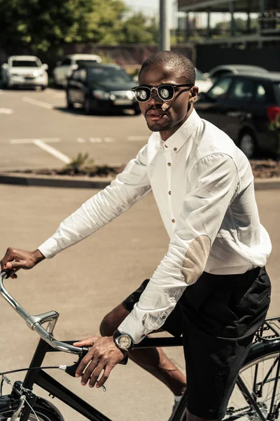 Homme élégant portant une chemise blanche à vélo sur la rue — Photo de stock