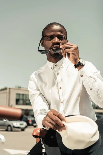 Uomo elegante con camicia bianca e occhiali da sole appoggiati sulla bici da città — Foto stock