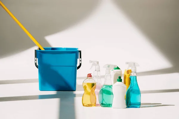 Diversos productos de limpieza, fregona y cubo en blanco - foto de stock