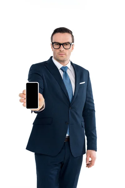 Handsme Geschäftsmann in Brille mit Smartphone mit leerem Bildschirm und Blick auf Kamera isoliert auf weiß — Stockfoto