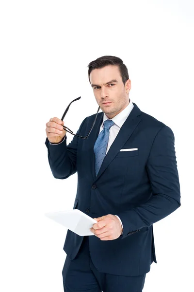 Homme d'affaires d'âge moyen tenant des lunettes et une tablette numérique et regardant la caméra isolée sur blanc — Photo de stock