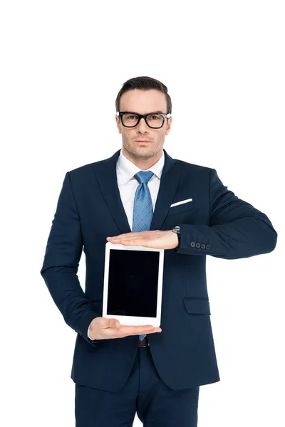Hombre de negocios con gafas de vista sosteniendo tableta digital con pantalla en blanco y mirando a la cámara aislada en blanco - foto de stock