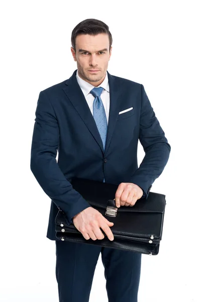 Серйозний бізнесмен середнього віку тримає портфель і дивиться на камеру ізольовано на білому — стокове фото