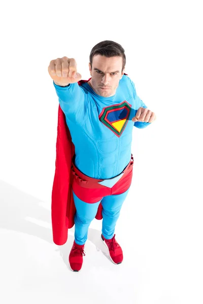 High angle view of handsome superhero raising hand and looking at camera on white — Stock Photo