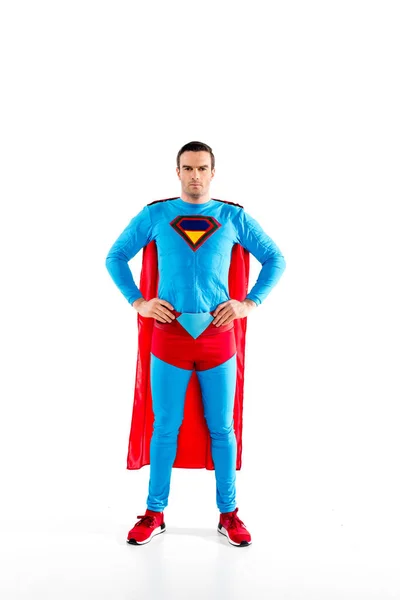 Повнометражний вигляд красивого середнього дорослого супермена, що стоїть з руками на талії і дивиться на камеру ізольовано на білому — стокове фото