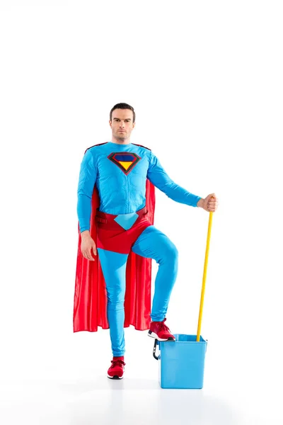 Confident man in superhero costume standing with mop and bucket, looking at camera on white — Stock Photo