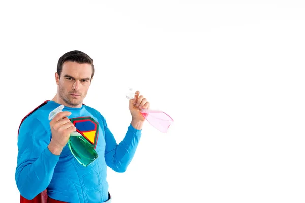 Selbstbewusster Superheld, der Plastiksprühflaschen mit Reinigungsflüssigkeit in der Hand hält und isoliert auf weiß in die Kamera schaut — Stockfoto