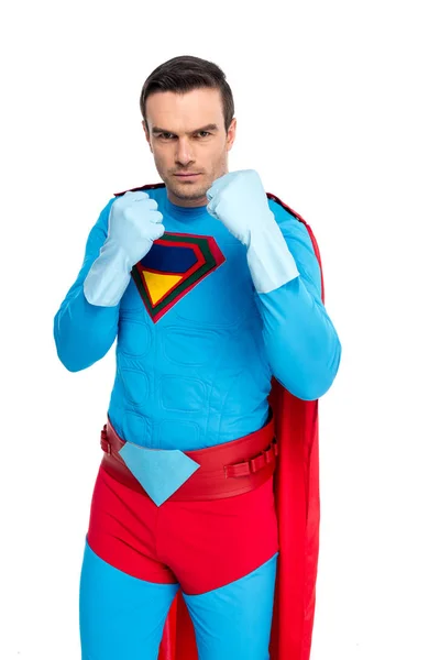 Serious male superhero in rubber gloves standing with fighting position and looking at camera isolated on white — Stock Photo