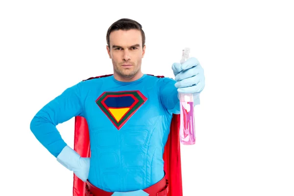 Super-herói masculino em luvas de borracha segurando frasco de spray com detergente e olhando para a câmera isolada no branco — Fotografia de Stock