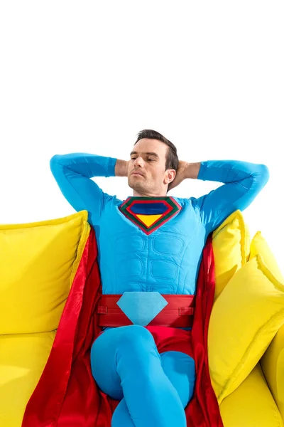 Красивий чоловічий супергерой, що відпочиває на жовтому дивані ізольовано на білому — стокове фото