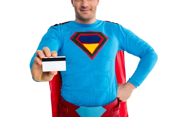 Cropped shot of smiling male superhero holding credit card isolated on white — Stock Photo