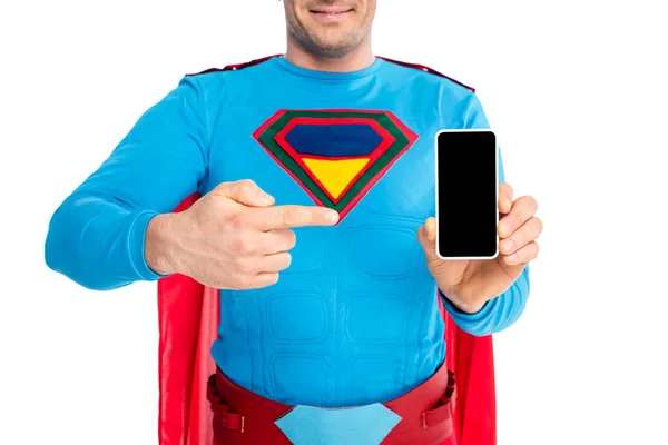 Plan recadré de l'homme en costume de super-héros pointant du doigt le smartphone avec écran blanc isolé sur blanc — Photo de stock