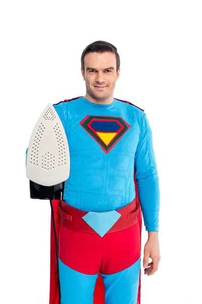 Красивий чоловік в костюмі супергероя тримає залізо і посміхається на камеру ізольовано на білому — стокове фото