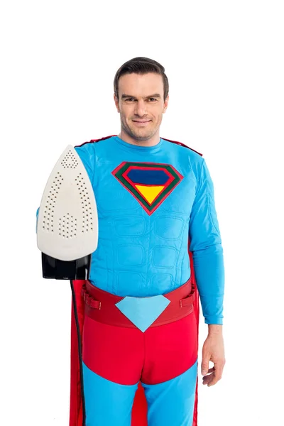 Handsome man in superhero costume holding iron and smiling at camera isolated on white — Stock Photo