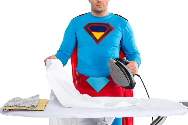 Ritagliato colpo di uomo in costume da supereroe stiratura vestiti isolati su bianco — Foto stock