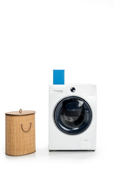 Blank box with soap powder on washing machine and laundry basket isolated on white — Stock Photo