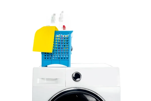 Cesta de plástico com suprimentos de limpeza na máquina de lavar roupa isolada em branco — Fotografia de Stock