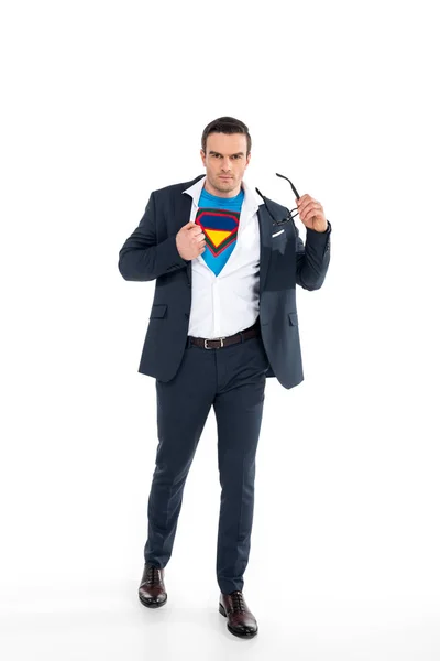 Uomo d'affari fiducioso in costume da supereroe sotto tuta togliersi gli occhiali e guardando la fotocamera isolata su bianco — Foto stock