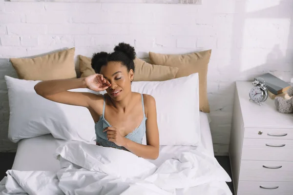 Молодая африканская американка просыпается в спальне — стоковое фото