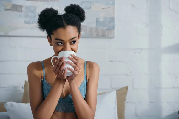 Привлекательная улыбающаяся афро девушка пьет кофе — стоковое фото