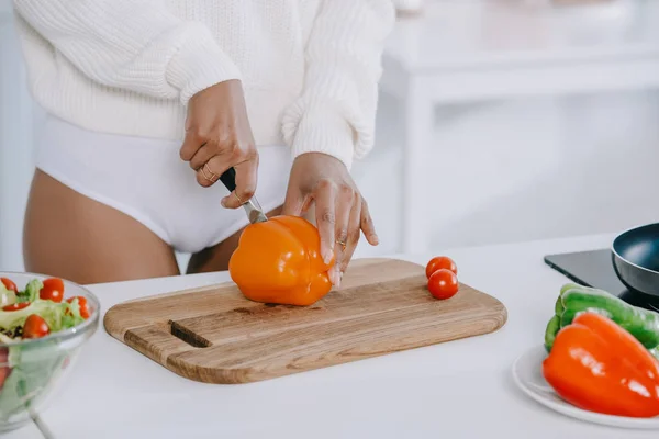 Tiro de mujer cortando verduras para el desayuno en la cocina - foto de stock