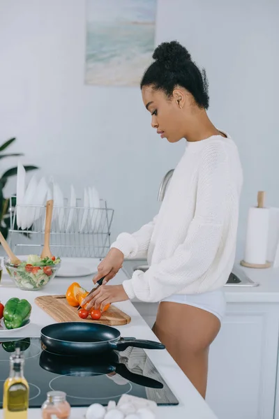 Hermosa mujer joven rebanando verduras para el desayuno en la cocina - foto de stock