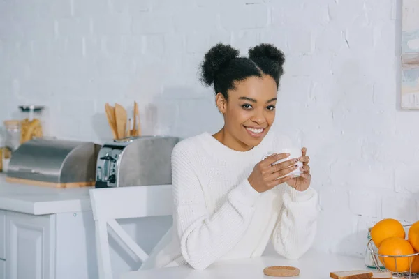 Schöne junge Frau mit einer Tasse Kaffee am Morgen zu Hause — Stockfoto