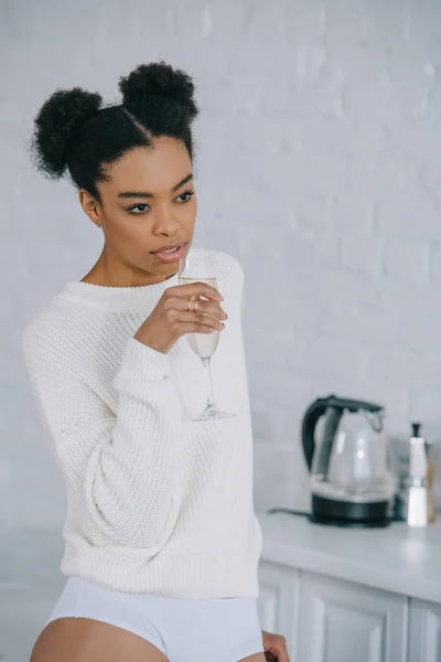 Attrayant jeune femme boire du champagne à la maison — Photo de stock